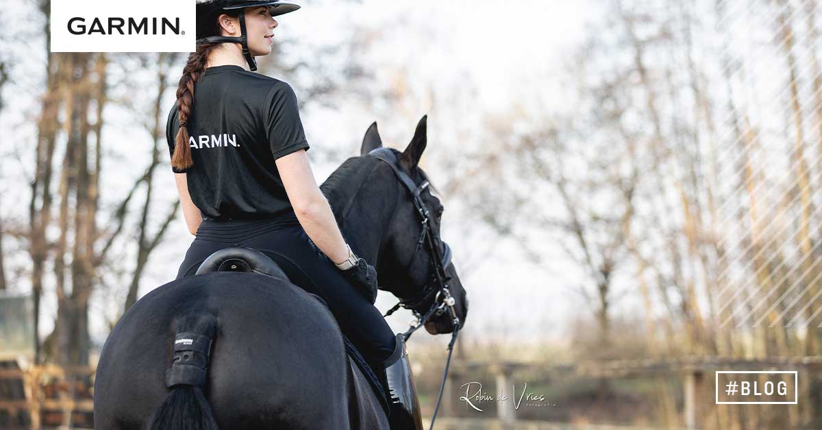 Kouluratsastaja mustan hevosen selässä Garmin Blaze -anturi kiinnitettynä hevosen hännän tyven alle